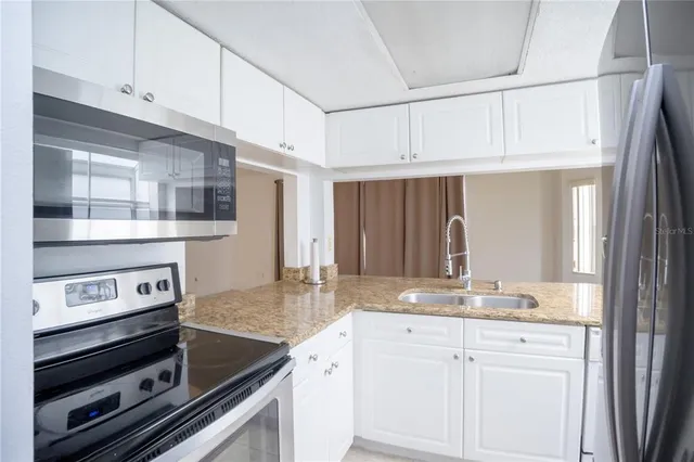 a kitchen with kitchen island granite countertop a stove and white cabinets