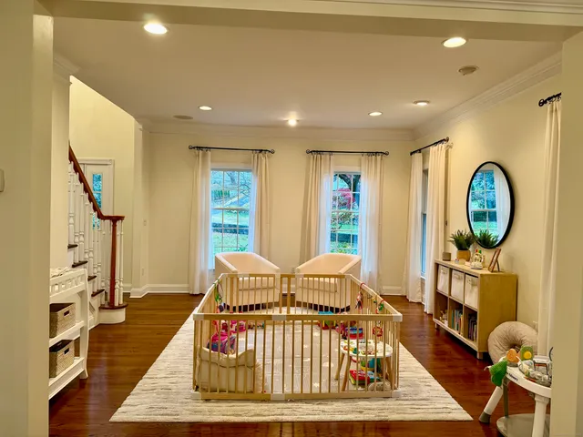 a living room with furniture fireplace dining table and a large window