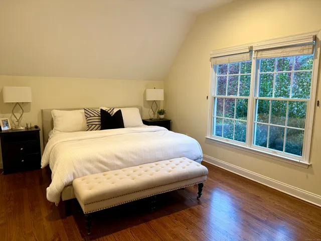 a bed sitting in a bedroom next to a window