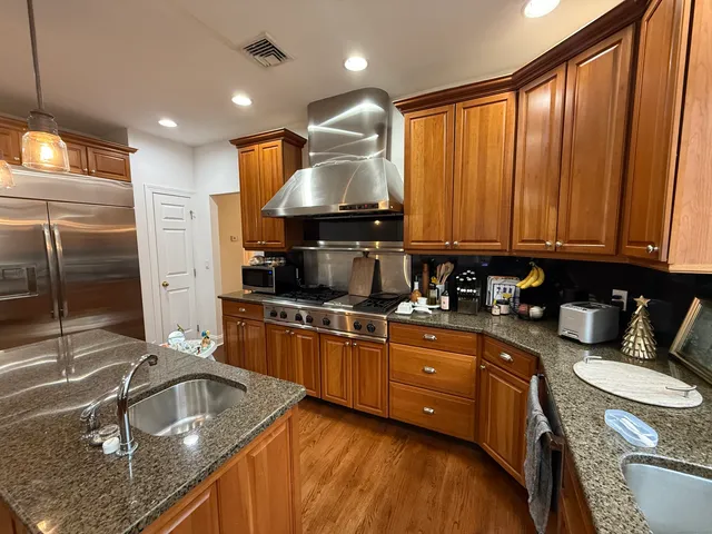 a kitchen with granite countertop a sink a stove and cabinets