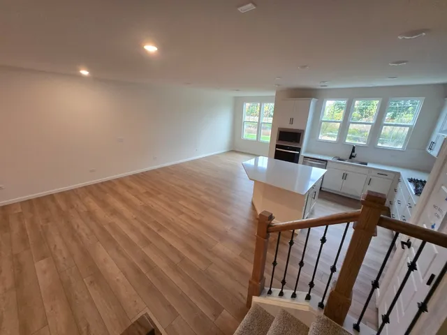 a large kitchen with stainless steel appliances granite countertop a stove a sink dishwasher a refrigerator and a stove with wooden floor