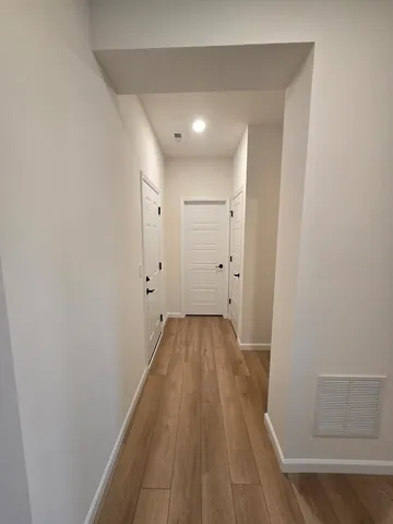 a view of a hallway with wooden floor