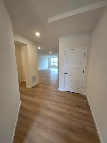 a view of an empty room with wooden floor