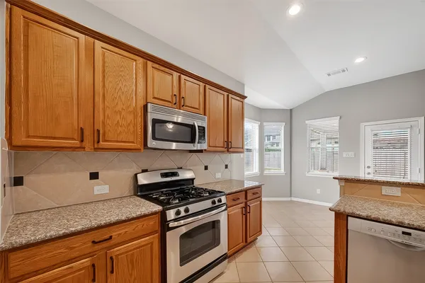 a kitchen with stainless steel appliances granite countertop a refrigerator stove and sink