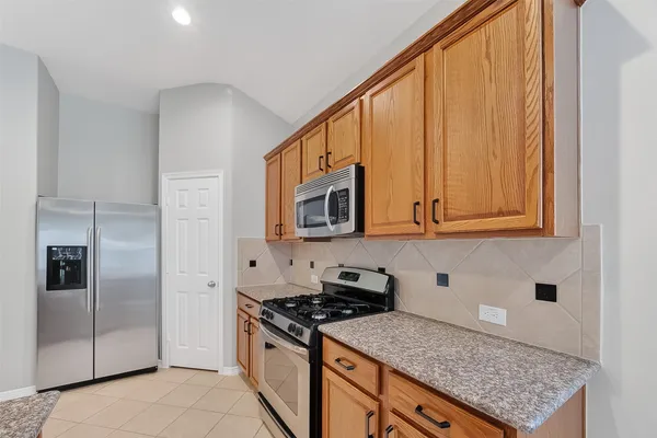 a view of a big room with wooden floor and a kitchen