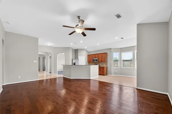 a living room with stainless steel appliances kitchen island granite countertop a sink cabinets and wooden floor