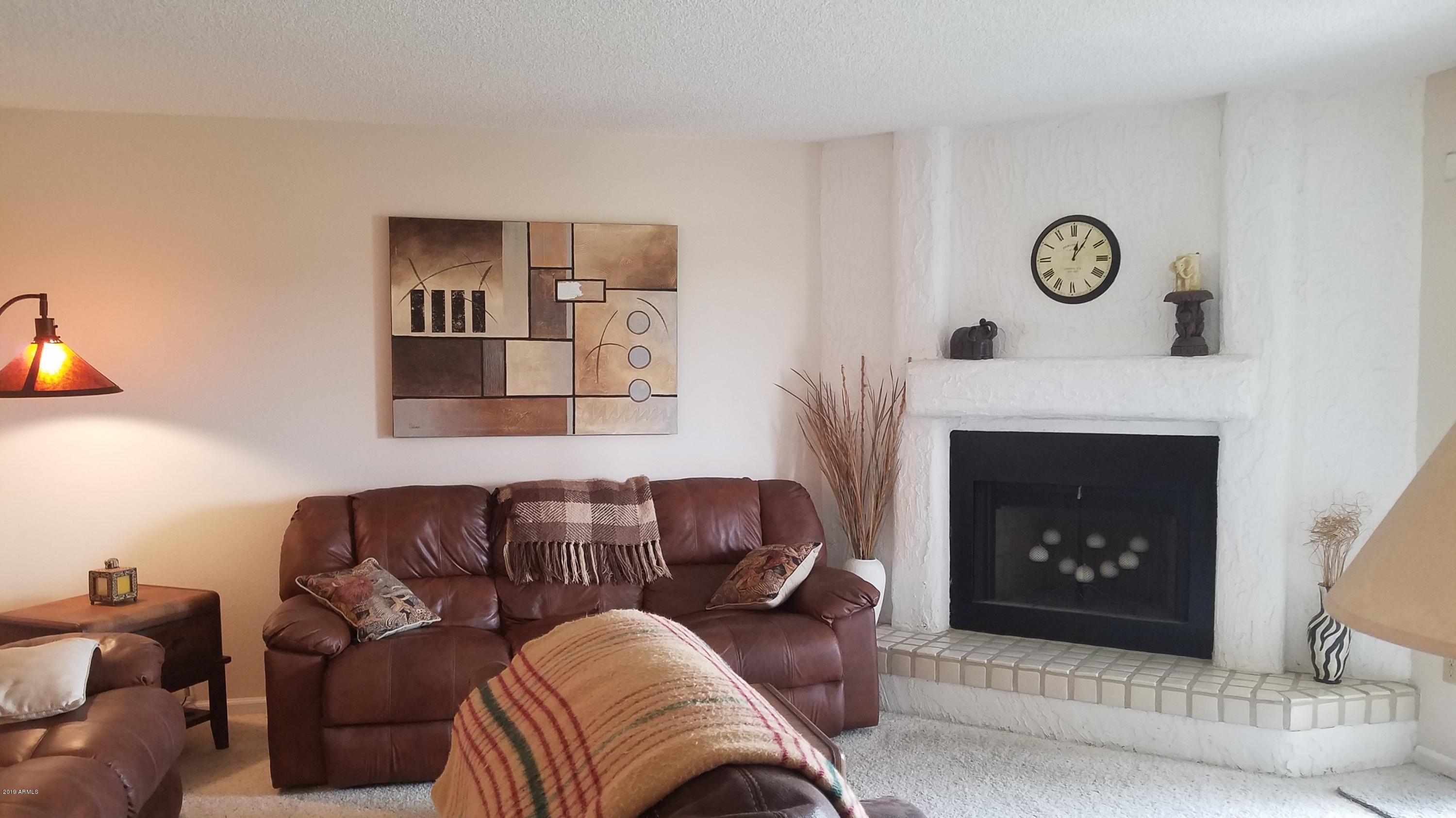 7061 East Broadway Road, Unit 48 Mesa, AZ 85208 - Photo 1 of 41 a living room with furniture a fireplace and a couch
