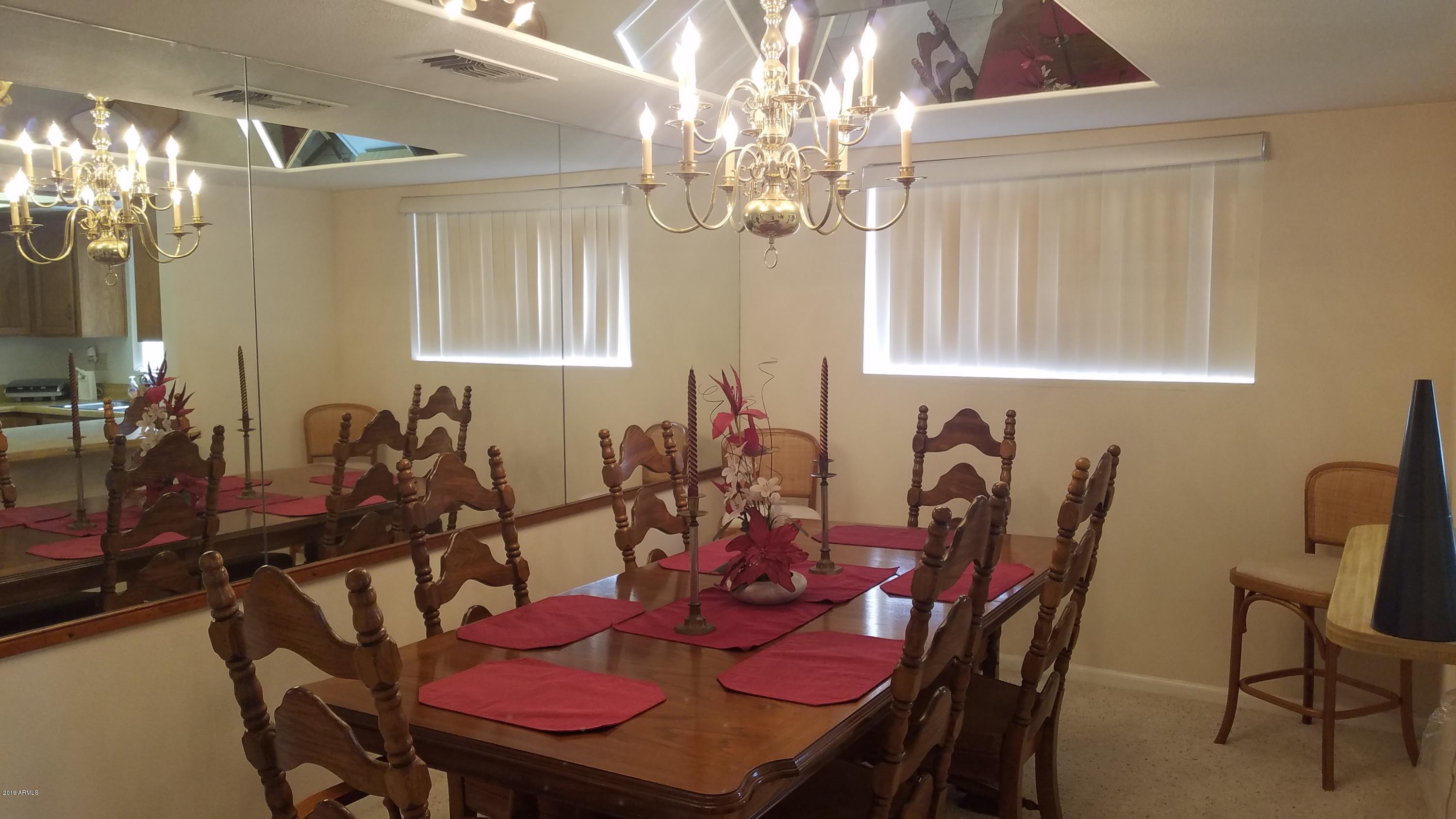 7061 East Broadway Road, Unit 48 Mesa, AZ 85208 - Photo 13 of 41 a view of a dining room with furniture and chandelier