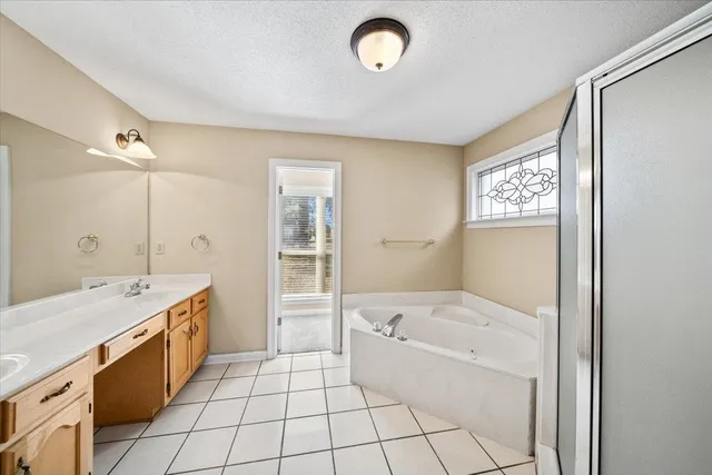 a bathroom with a tub sink and mirror