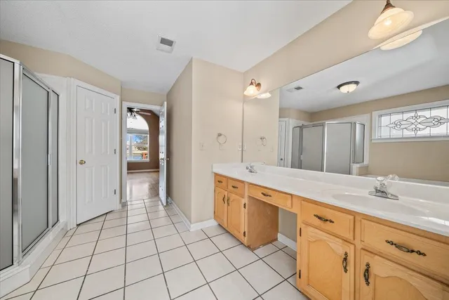 a spacious bathroom with a granite countertop sink mirror and shower
