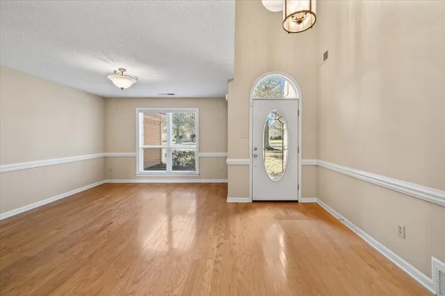 an empty room with window wooden floor and door