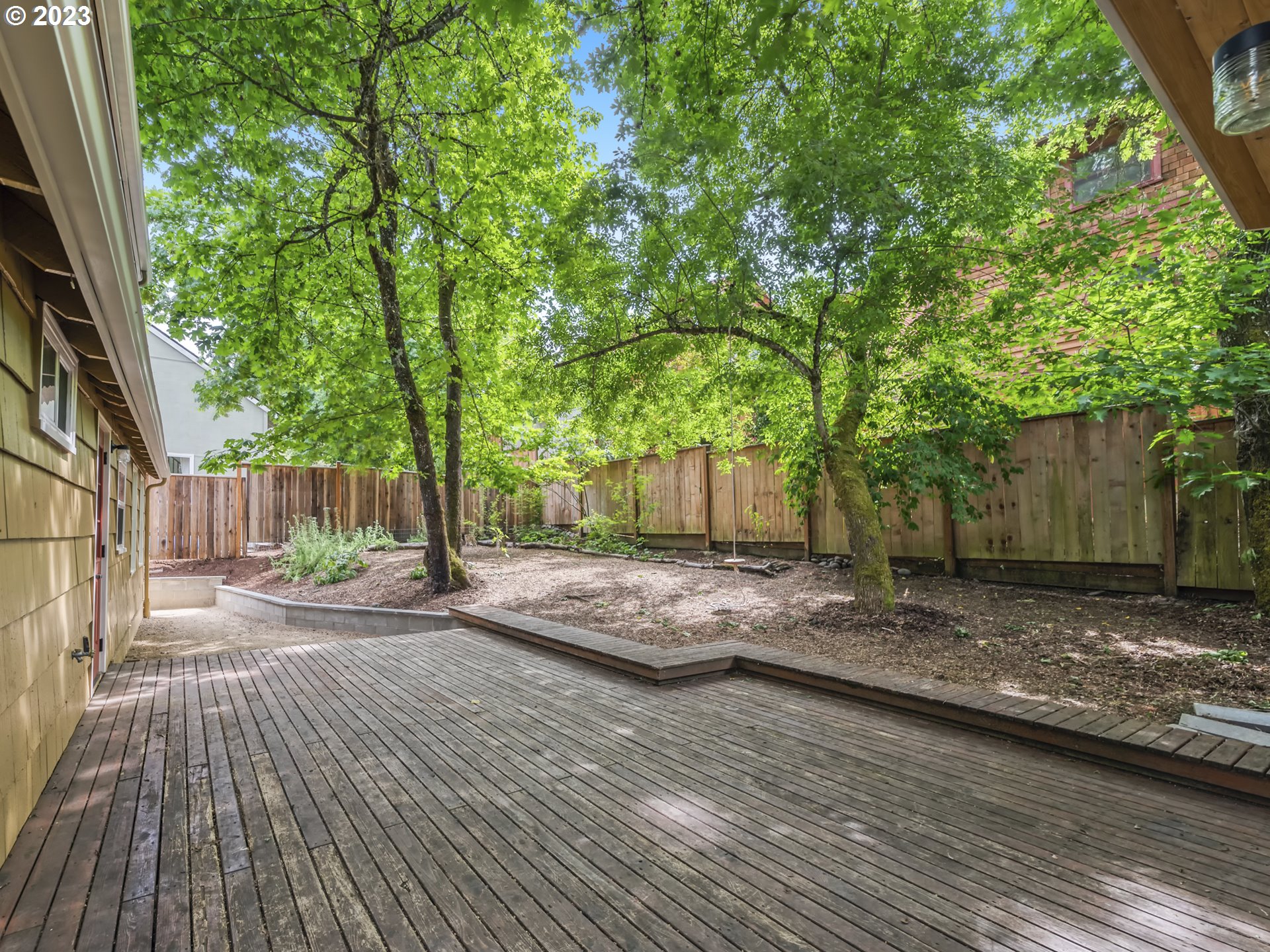2660 Emerald Street Eugene, OR 97403 - Photo 24 of 36 a view of a backyard with large trees and wooden fence