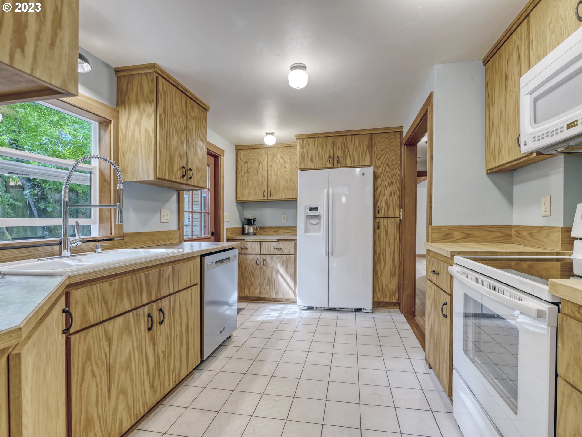 2660 Emerald Street Eugene, OR 97403 - Photo 8 of 36 a kitchen with a sink a refrigerator and cabinets