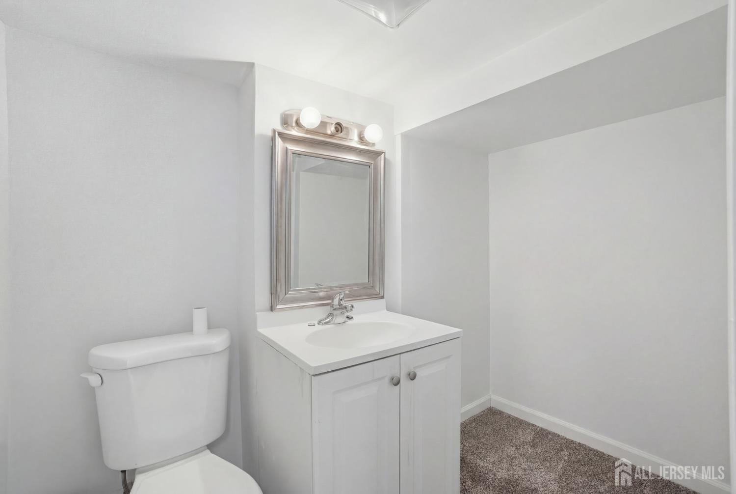 241 Hillside Road Elizabeth, NJ 07208 - Photo 21 of 33 a bathroom with a toilet a sink and mirror