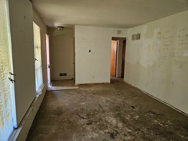 an empty room with closet and windows