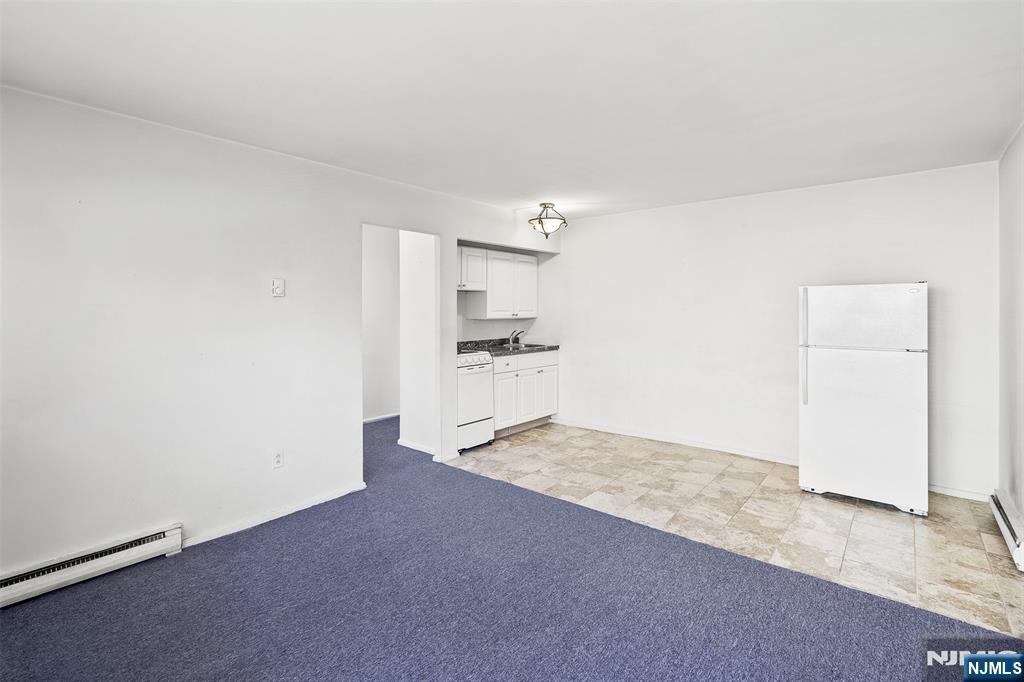64 Poplar Avenue, Unit A7 Hackensack, NJ 07601 - Photo 3 of 10 a view of a kitchen with a sink and a refrigerator