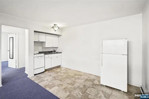 a kitchen with white cabinets and white appliances