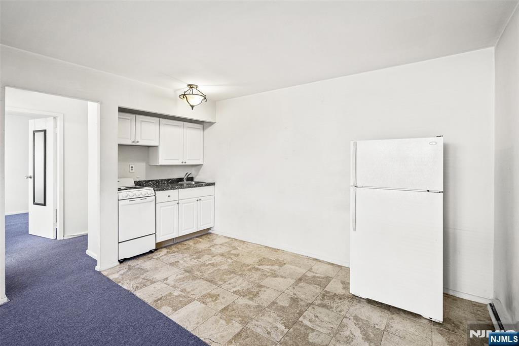 64 Poplar Avenue, Unit A7 Hackensack, NJ 07601 - Photo 4 of 10 a kitchen with white cabinets and white appliances