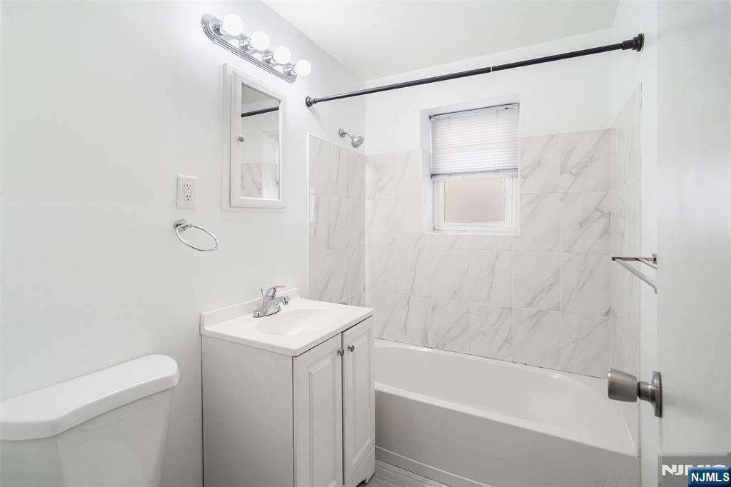 64 Poplar Avenue, Unit A7 Hackensack, NJ 07601 - Photo 6 of 10 a bathroom with a sink a toilet and shower