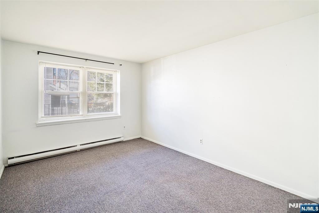 64 Poplar Avenue, Unit A7 Hackensack, NJ 07601 - Photo 7 of 10 an empty room with windows