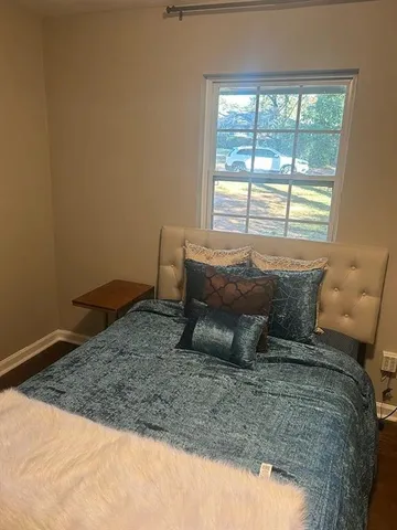 a bed sitting in a bedroom next to a window