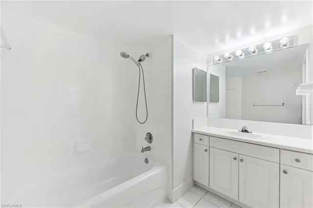 a bathroom with a double vanity sink mirror and bathtub