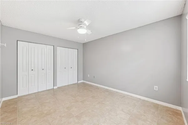 a view of an empty room and chandelier fan