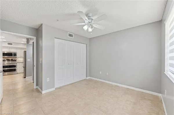 an empty room with closet and fan