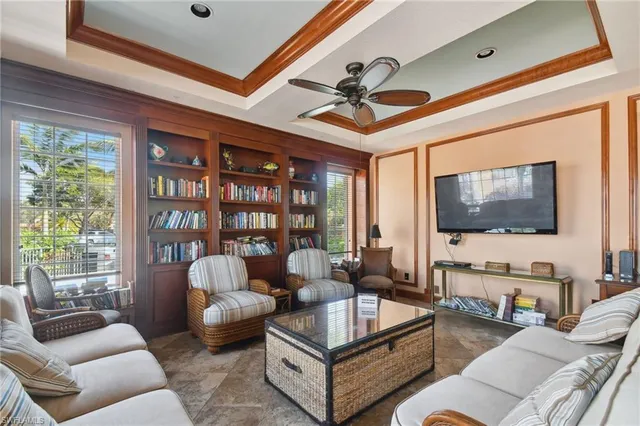 a living room with furniture a flat screen tv and a large window