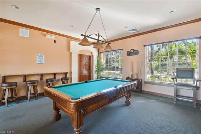 a room with pool table and windows
