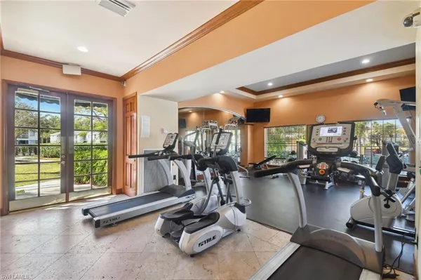 a room with gym equipment and large windows