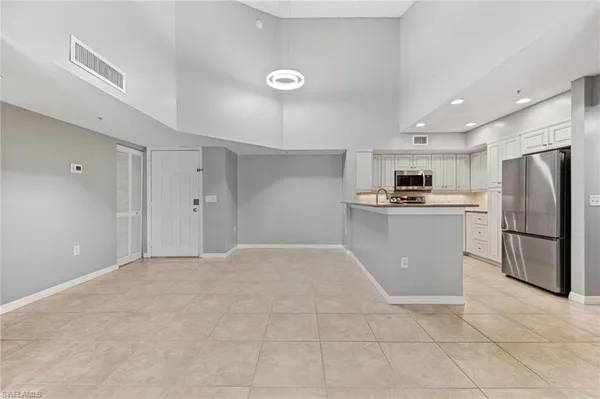 a kitchen with a refrigerator a stove top oven and white cabinets