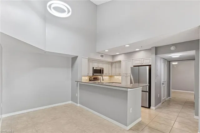 a kitchen with kitchen island a refrigerator sink and cabinets