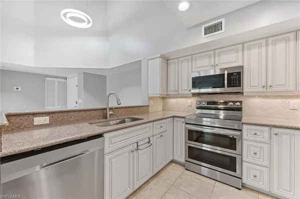 a kitchen with appliances a sink and cabinets