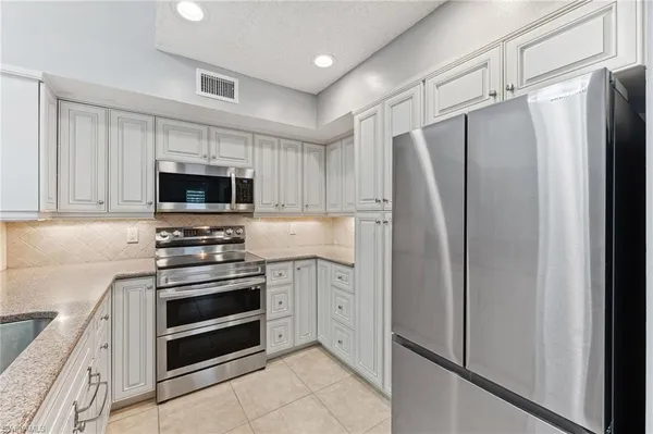 a kitchen with stainless steel appliances a refrigerator stove and microwave