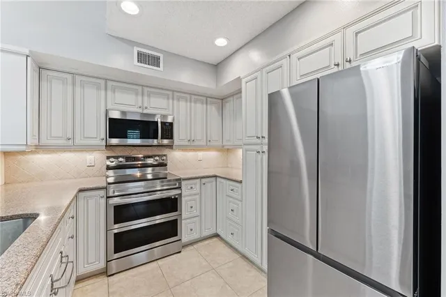 a kitchen with stainless steel appliances a refrigerator stove and microwave
