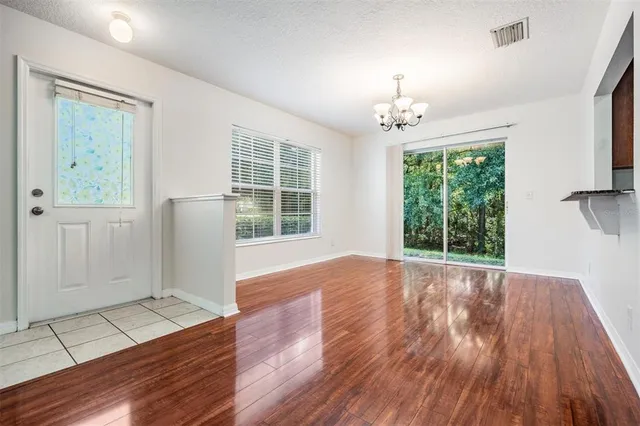 an empty room with wooden floor windows and cabinet