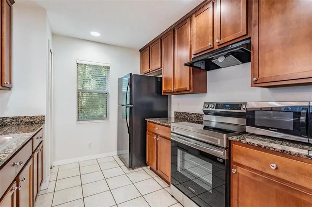 a kitchen with stainless steel appliances granite countertop a stove a refrigerator and a cabinets