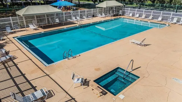a view of a swimming pool with a patio and a yard