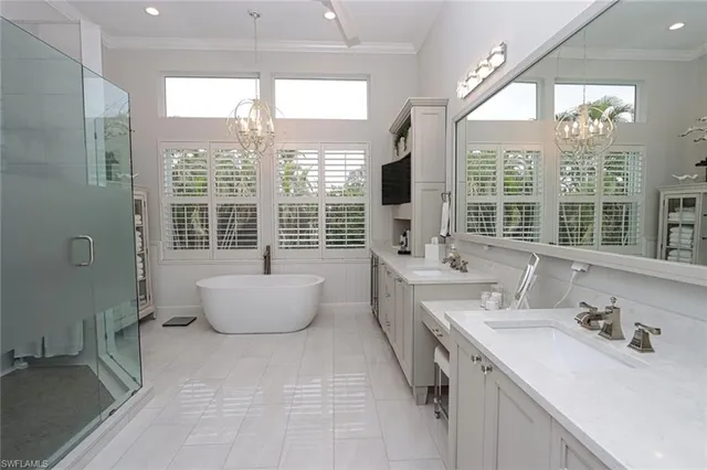 a spacious bathroom with a double vanity sink large mirror and a large window