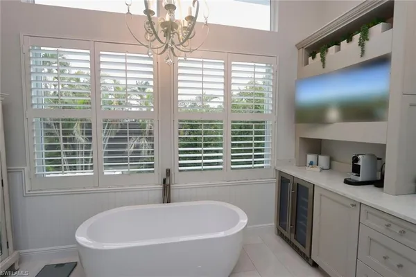 a bathroom with a bathtub a window and a vanity