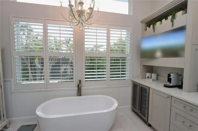 a bathroom with a bathtub a window and a vanity