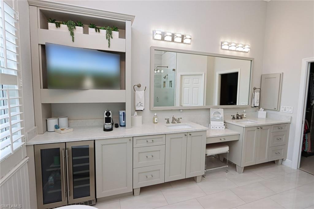 1165 4th Street South, Unit 2 Naples, FL 34102 - Photo 21 of 34 a bathroom with a double vanity sink and mirror