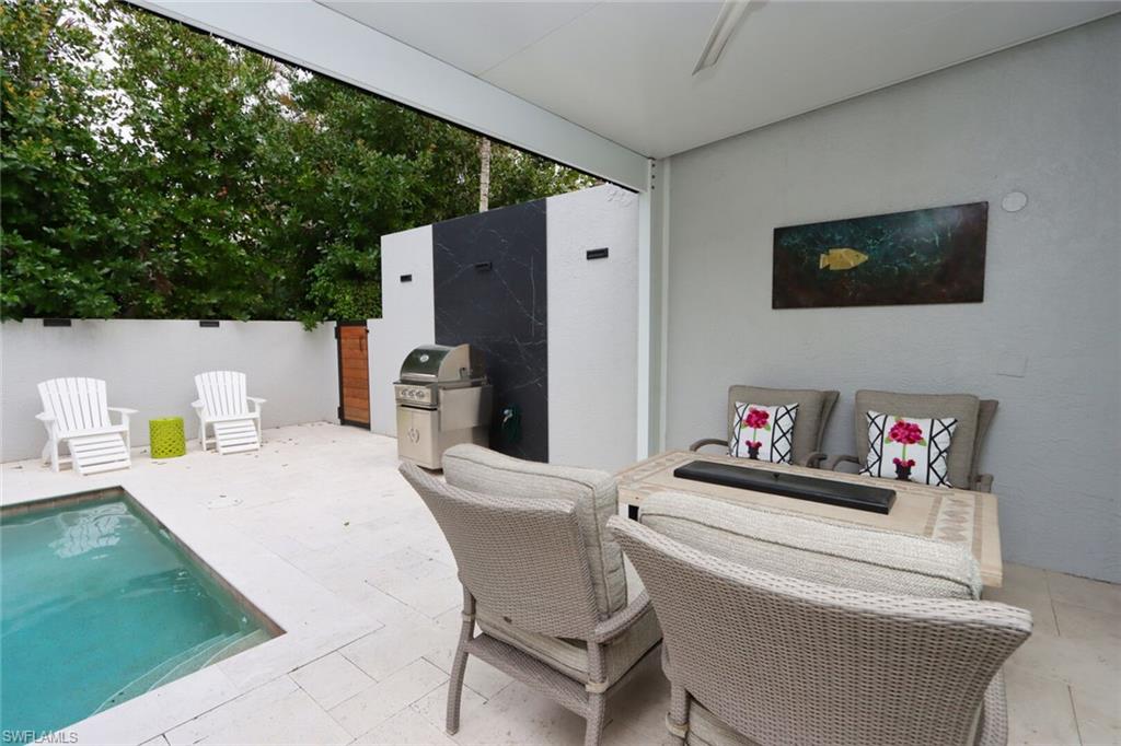 1165 4th Street South, Unit 2 Naples, FL 34102 - Photo 29 of 34 a living room with furniture and a wooden floor