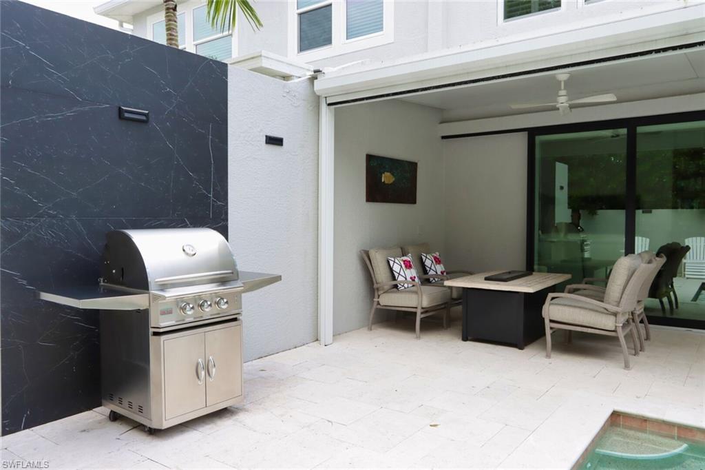 1165 4th Street South, Unit 2 Naples, FL 34102 - Photo 33 of 34 a roof deck with table and chairs