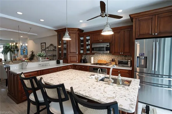 a kitchen with stainless steel appliances kitchen island granite countertop a dining table and chairs