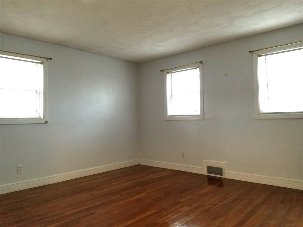 225 Governors Road, Unit 225 Quincy, MA 02169 - Photo 13 of 19 a view of an empty room with wooden floor and a window