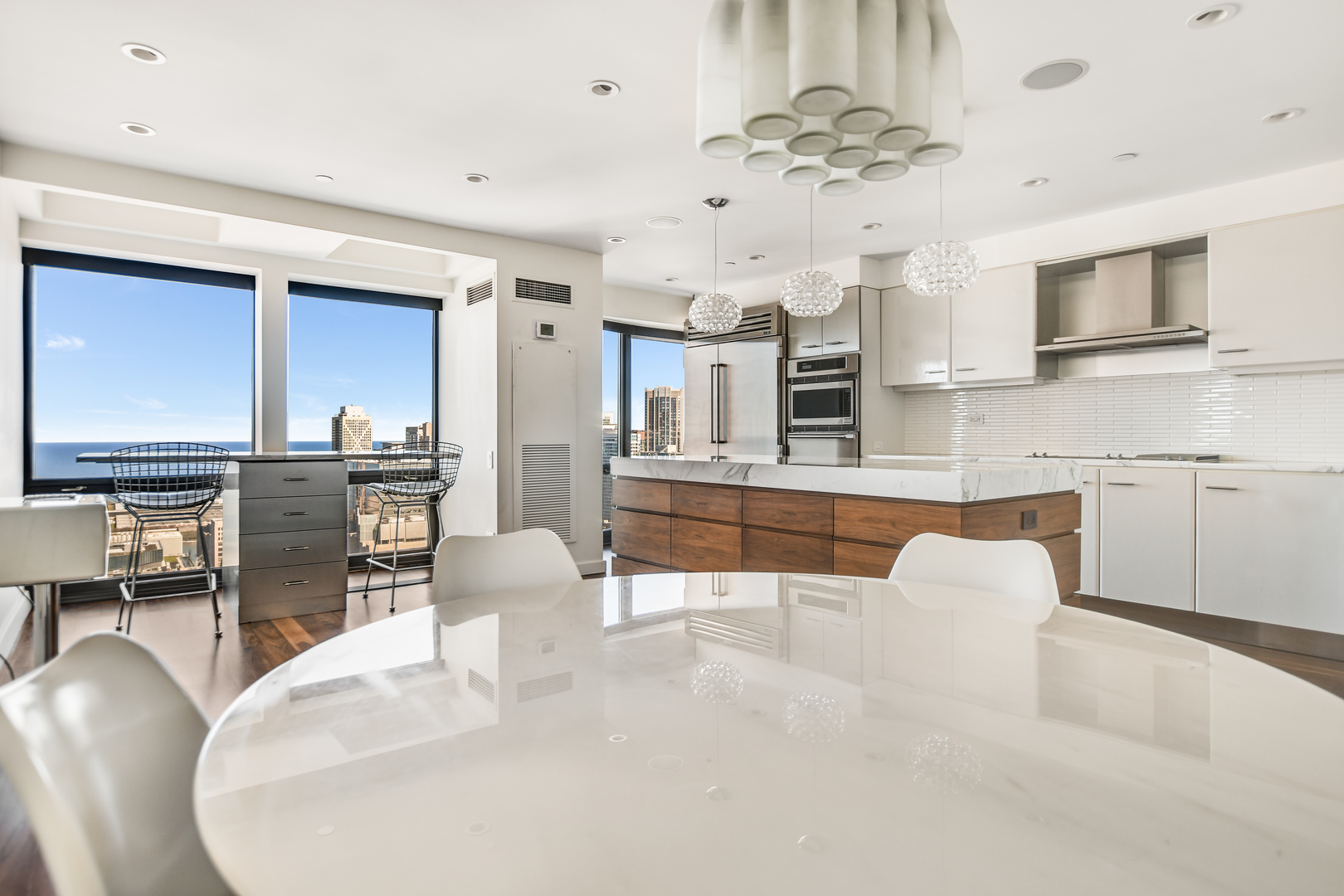 100 East Huron Street, Unit 4002 Chicago, IL 60611 - Photo 19 of 49 a kitchen with stainless steel appliances kitchen island granite countertop a table and chairs in it