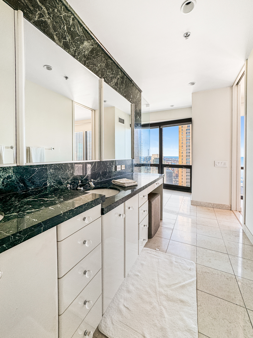 100 East Huron Street, Unit 4002 Chicago, IL 60611 - Photo 30 of 49 a large kitchen with granite countertop a stove a sink and a microwave