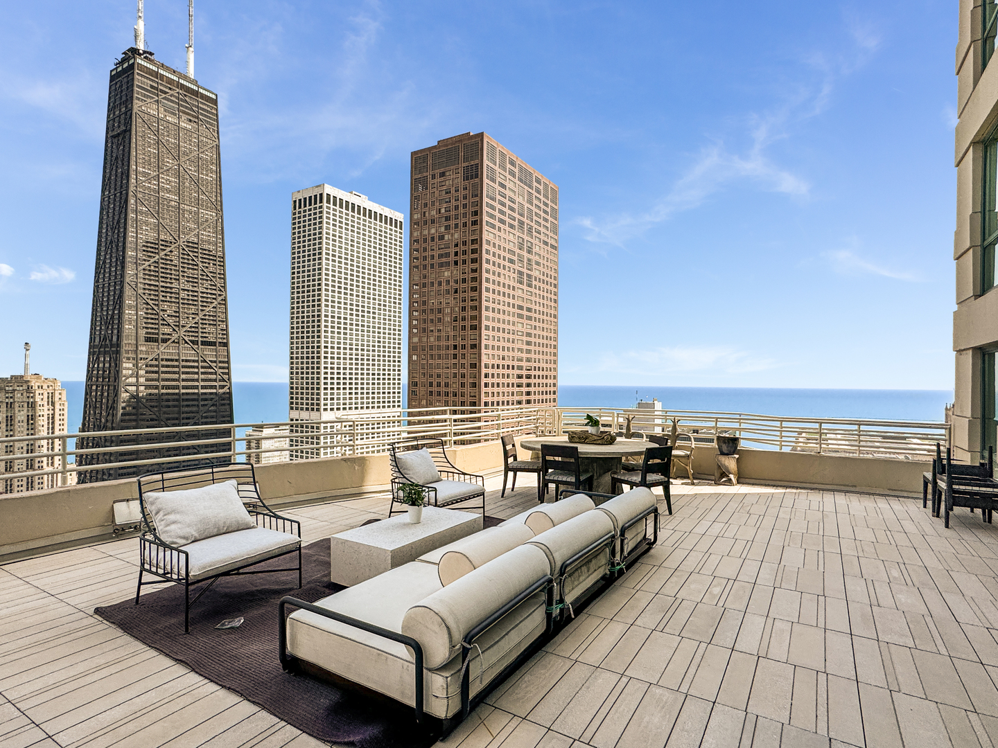 100 East Huron Street, Unit 4002 Chicago, IL 60611 - Photo 8 of 49 a balcony with wooden floor and furniture